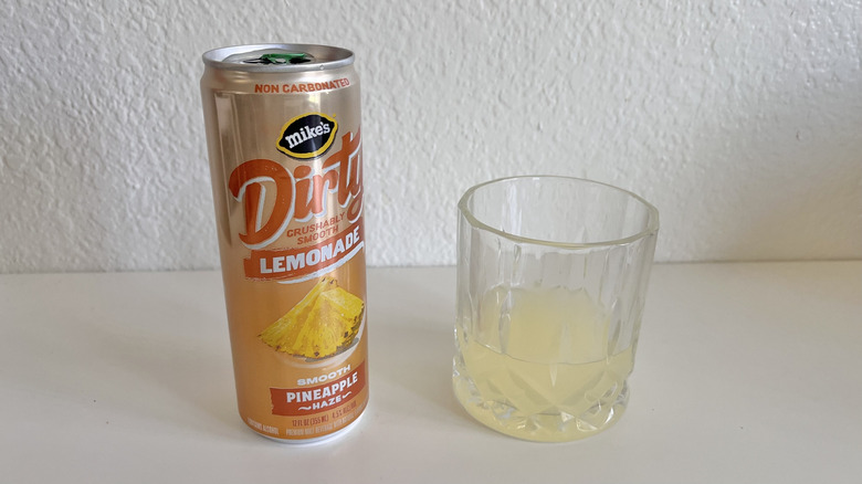Dirty Lemonade Pineapple Haze can on a table next to a glass