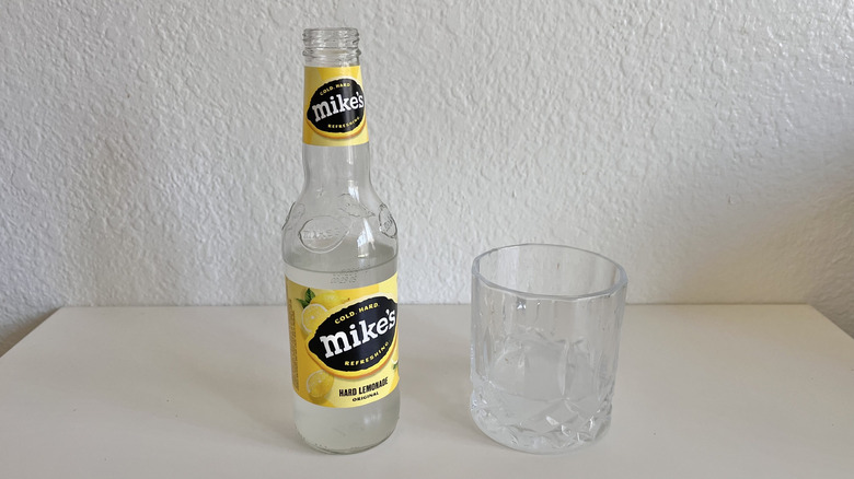 Original Mike's Hard Lemonade bottle on a table next to a glass