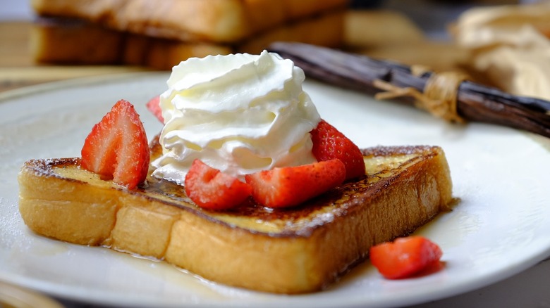 french toast on plate with berries and cream