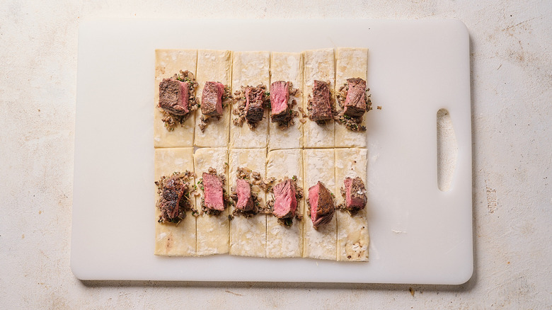 adding steak to puff pastry pieces