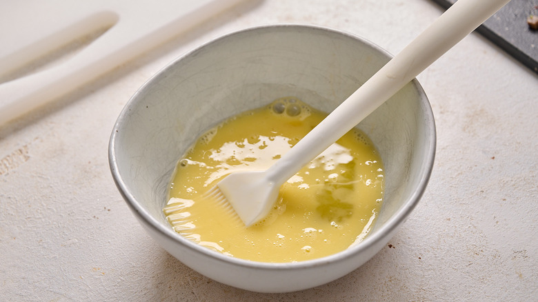 stirring egg and water together in a bowl
