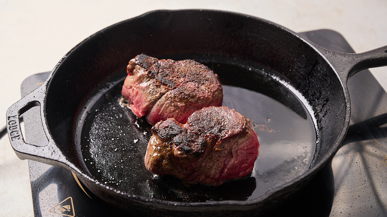 searing filet mignon in a skillet