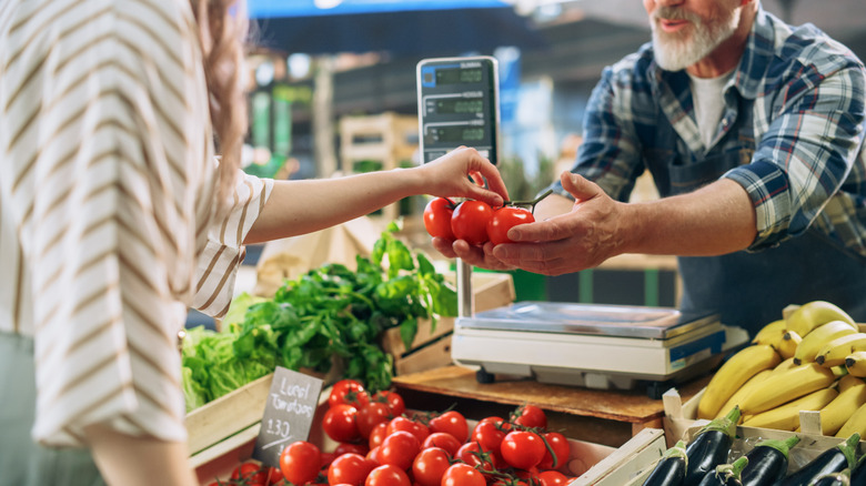 Person buying fresh produce from a farmer at farmers market
