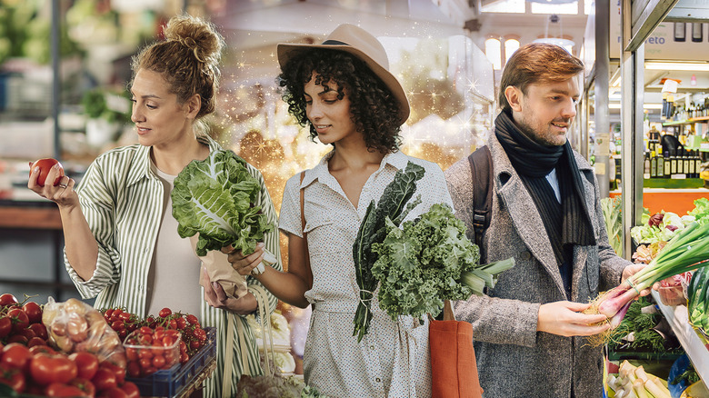 Three people holding produce in farmers market
