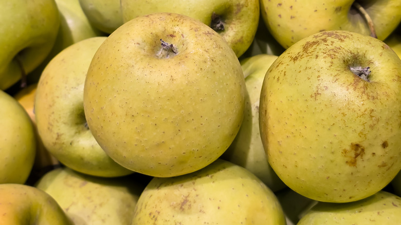 Bruised green apples in pile