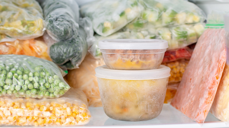 Frozen food in plastic containers and zip lock bags in the freezer