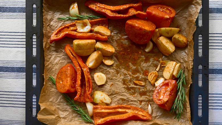 Vegetables on used parchment paper on baking sheet