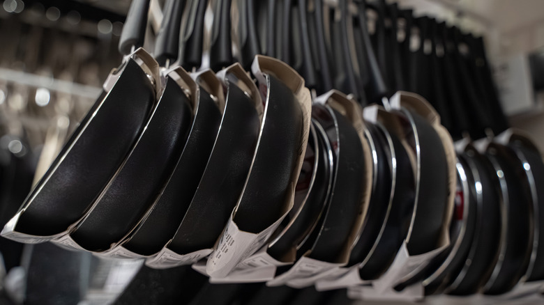 Store display of lightweight skillets hanging from a peg