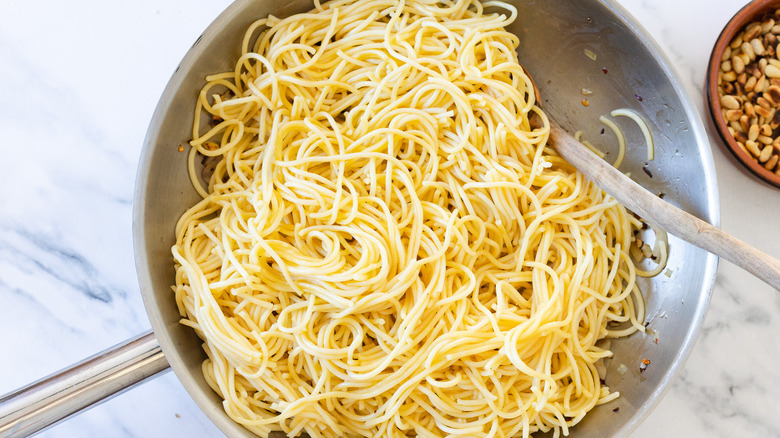 Pasta with tongs in a pan.