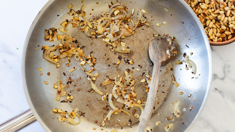 Garlic, chile and wooden spoon in a pan.