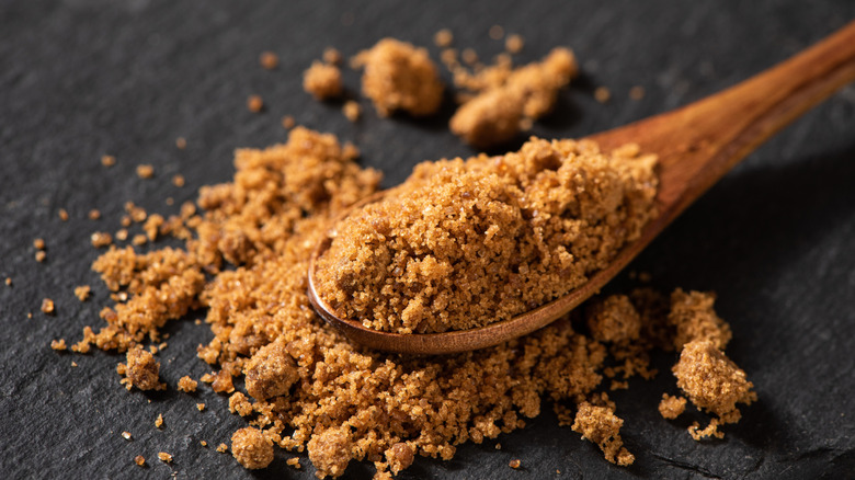 Brown sugar on wooden spoon.