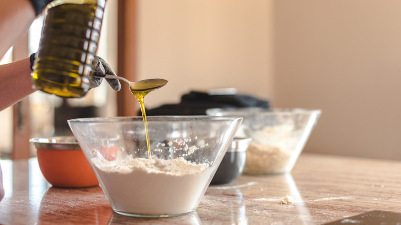 Pouring oil into cake batter.
