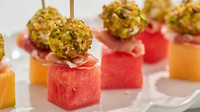 melon, prosciutto, and pistachio goat cheese skewers on platter