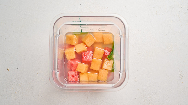 soaking melons in container filled with mojito