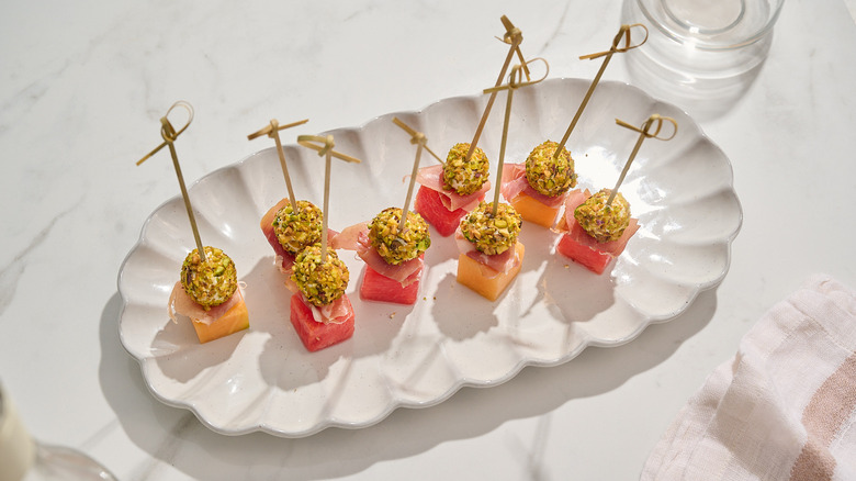 melon and prosciutto skewers on a platter