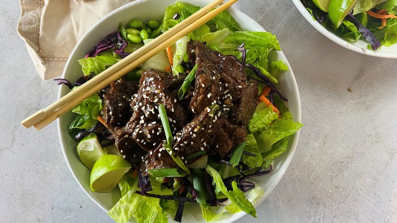 salad with asian beef and chopsticks