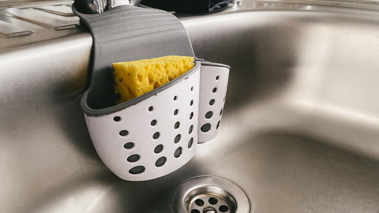 Sponge holder basket attached to the side of a sink