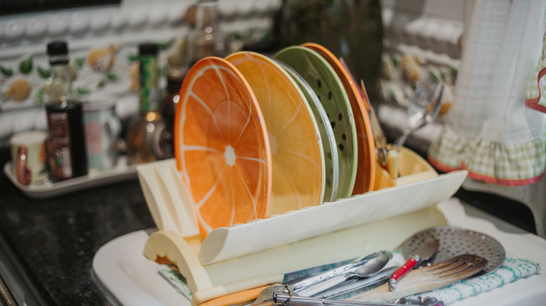Colorful fruit-themed plates on a white folding dish rack