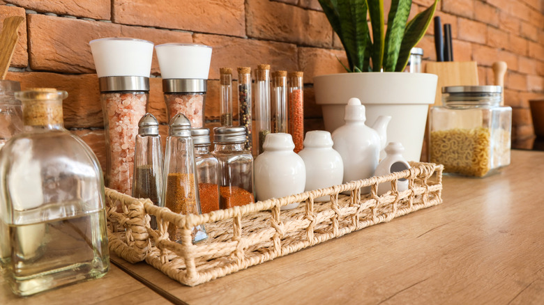 A wicker tray with various spices and small jars on it