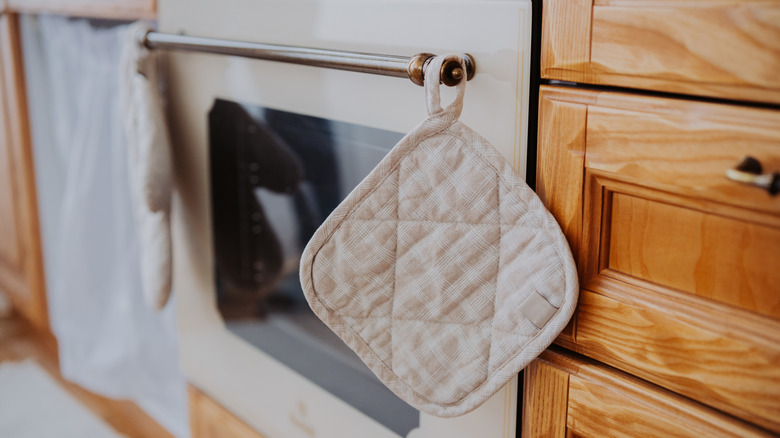 White oven mitts hung on oven handle