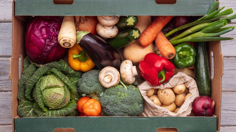 Overview of a cardboard box of various fresh vegetables