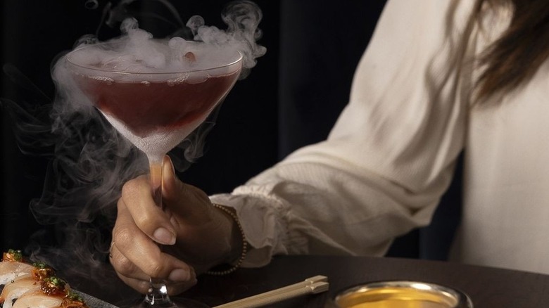 server at Ocean Prime holding smoke-filled cocktail