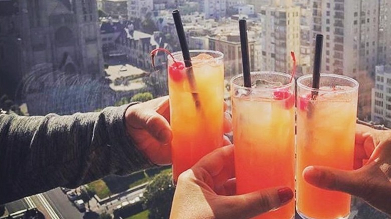 Hands clinking glasses at Top of the Mark