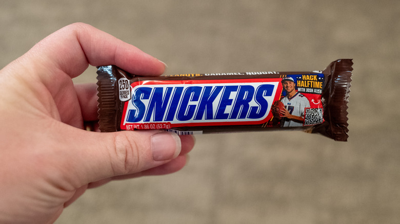Person holding a Snickers bar