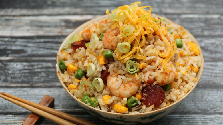 A bowl of Chinese fried rice has shrimp and vegetables.