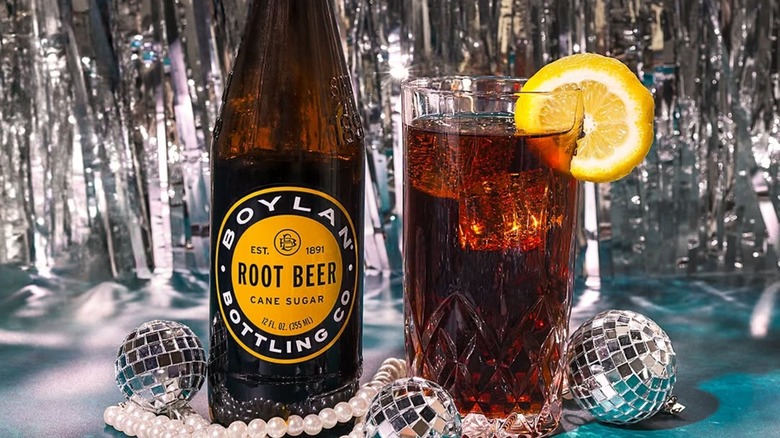 Bottle of Boylan root beer with a glass, mini disco balls, and a string of pearls