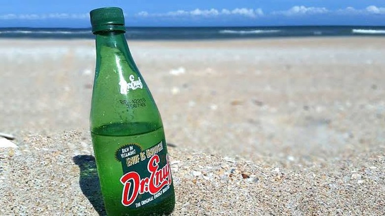 Bottle of Dr. Enuf sitting in the sand at the beach