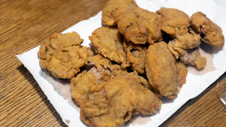 White plate of Rocky Mountain oysters on wooden table