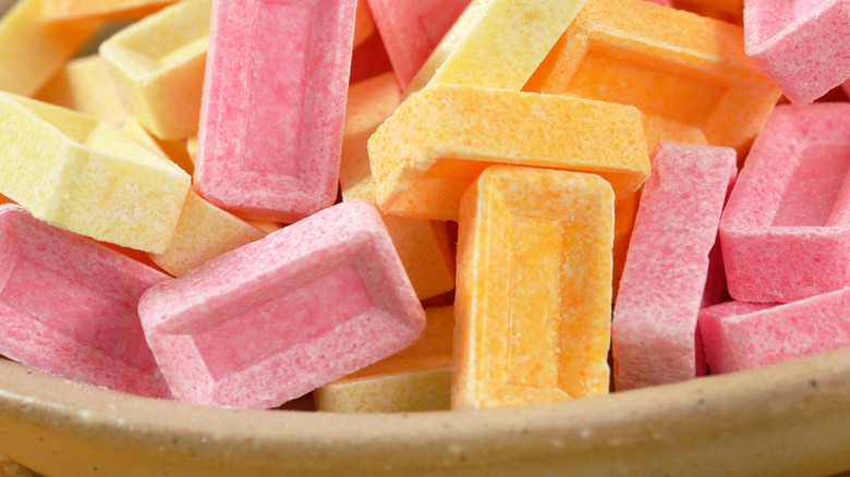 Assorted Pez candies in bowl on wooden table