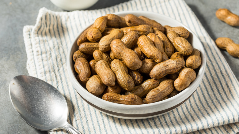 White bowl of boiled peanuts on dish towel