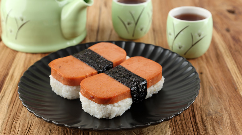 Black plate with Hawaiian spam musubi on wooden table