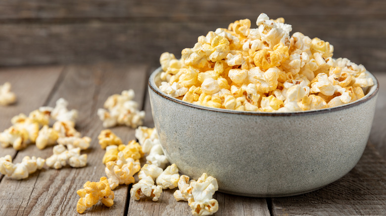 White bowl of popcorn on wooden table
