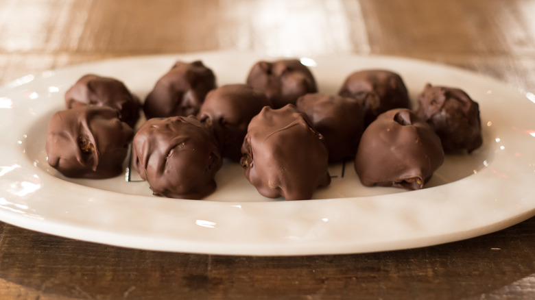 White platter of chocolate bourbon balls on wooden table