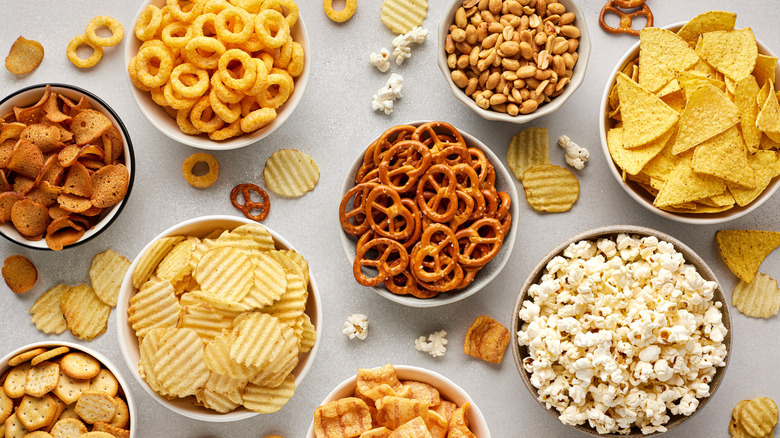 Bowls of assorted snacks on white table