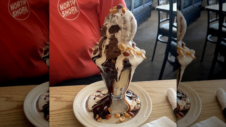Tin Roof sundae in glass cup on white plate