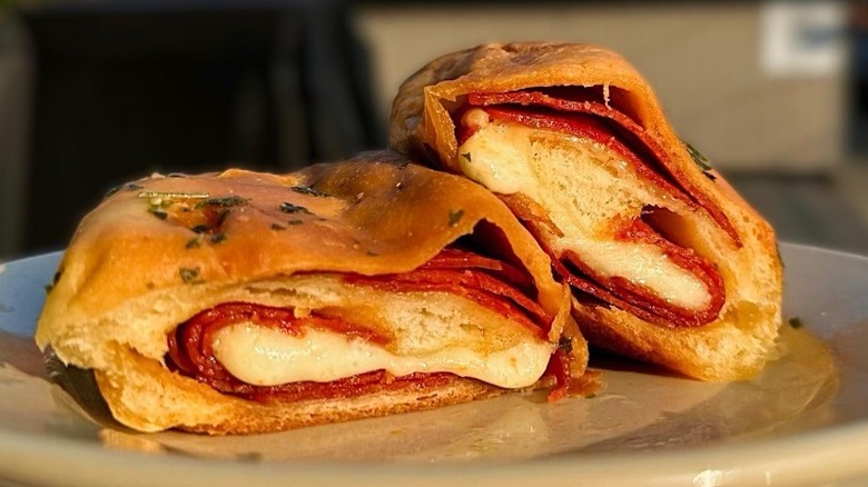 Pepperoni rolls cut in half on white plate