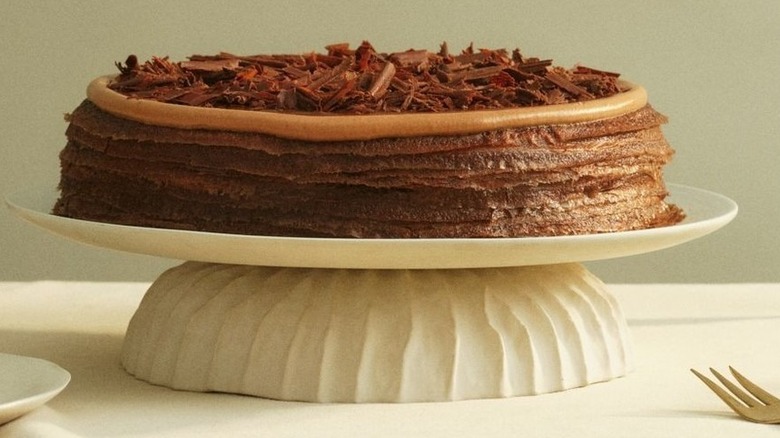 Lady M stacked chocolate mille crêpes cake on a white cake stand