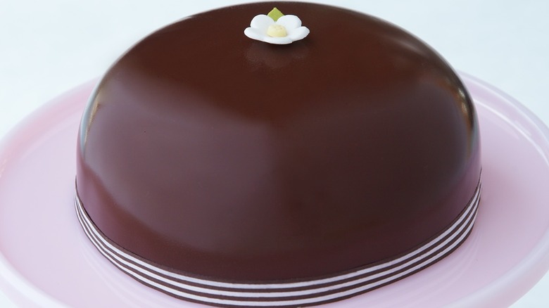 Miette bakery Scharffen Berger cake on a pink plate garnished with a marzipan flower