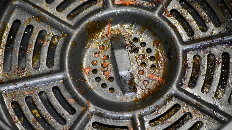 Dirty air fryer base with stuck-on food