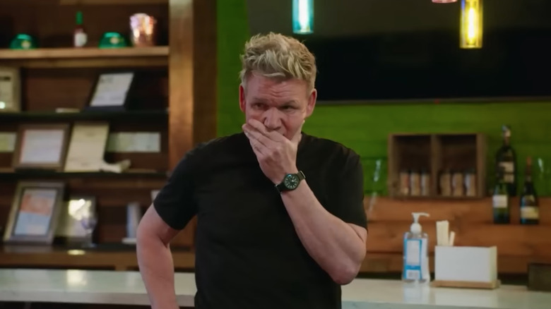 Gordon Ramsay with hand over mouth in a restaurant on set of Kitchen Nightmares