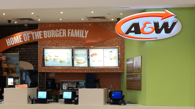 A sign hanging over a cashier station that says A&W