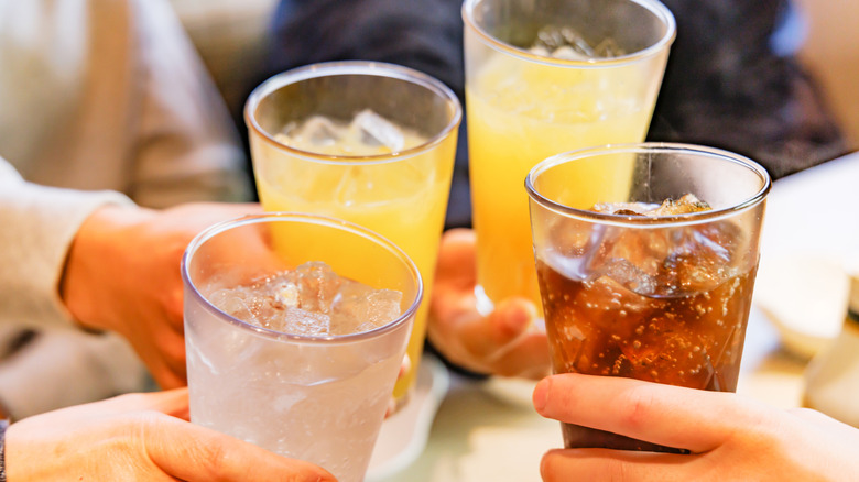 people holding different drinks on ice