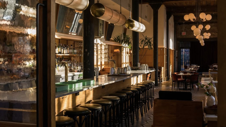 A sunlit dining room and bar with wooden accents