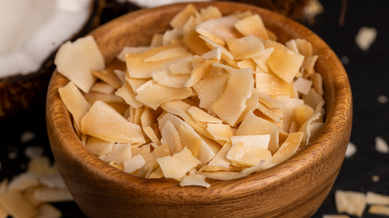 Toasted coconut flakes in a wooden bowl