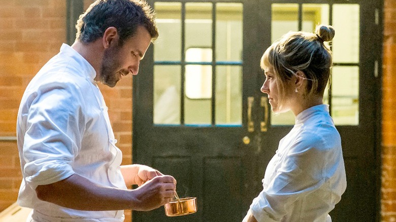A still from "Burnt" depicting Helene and Adam having a difficult conversation outside the restaurant