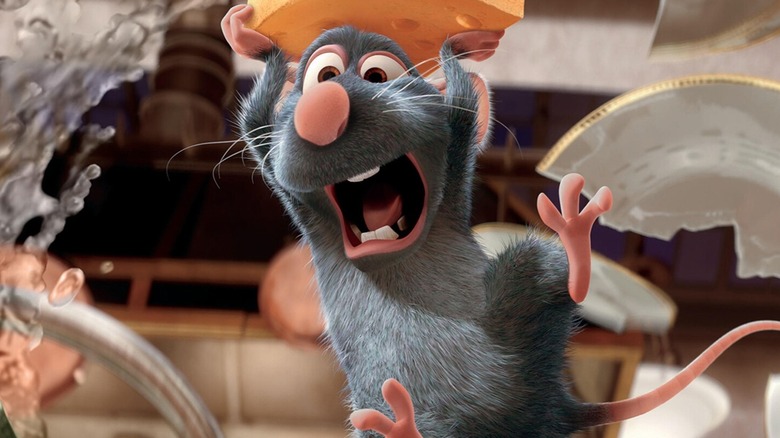 A still from "Ratatouille" in which Remy the rat holds a piece of cheese while soaring through the kitchen while dishes break and water splashes behind him
